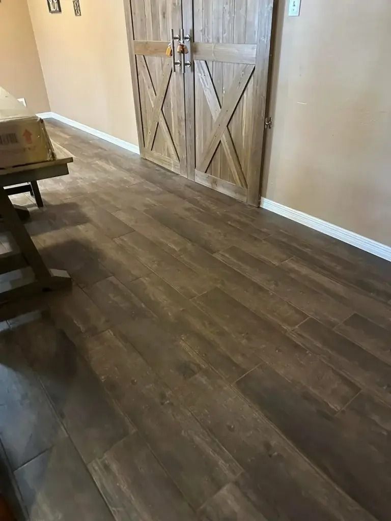 Wooden barn-style sliding doors in a room with dark wood flooring and beige walls