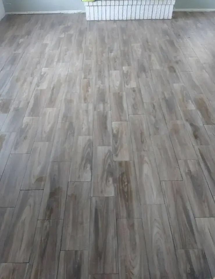 Empty room with gray wood-look flooring and a white baseboard radiator at the far wall