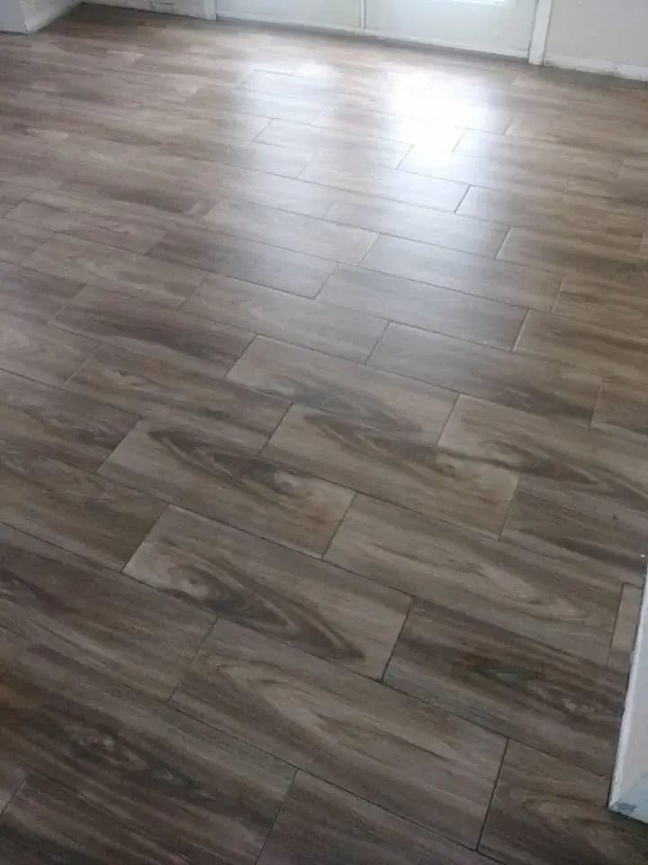 Wood-look tile flooring in a room, with light reflecting near a doorway.