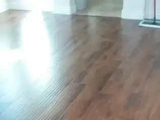 Empty room with light wood flooring and sunlight reflecting near white walls