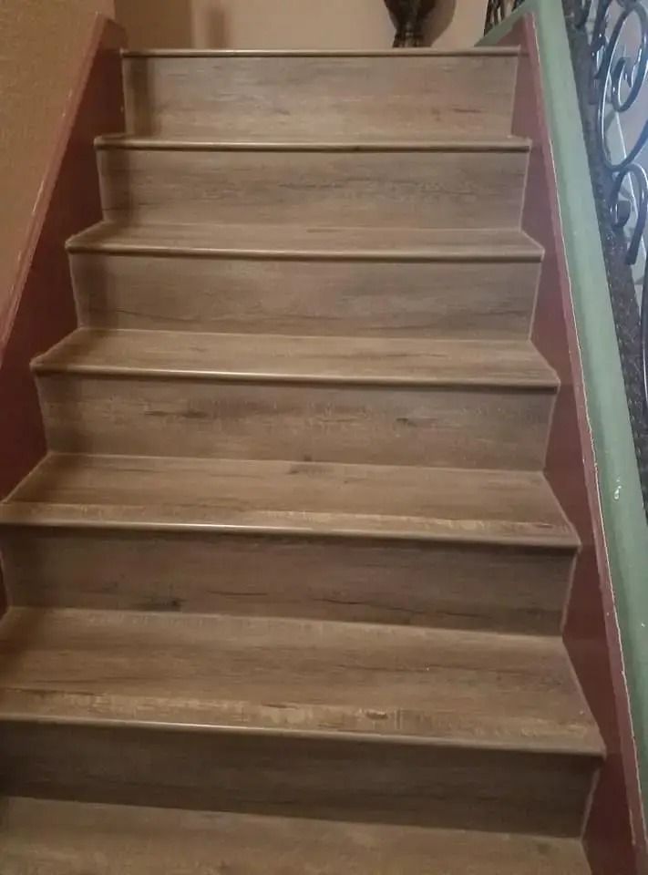 Wooden staircase with reddish-brown side walls and beige carpeted steps indoors