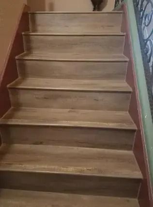 Wooden indoor staircase with carpet-free steps and red side walls