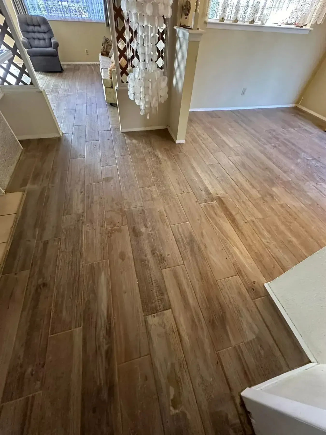 Empty room with light wood flooring, white walls, and a lattice partition near an open doorway.