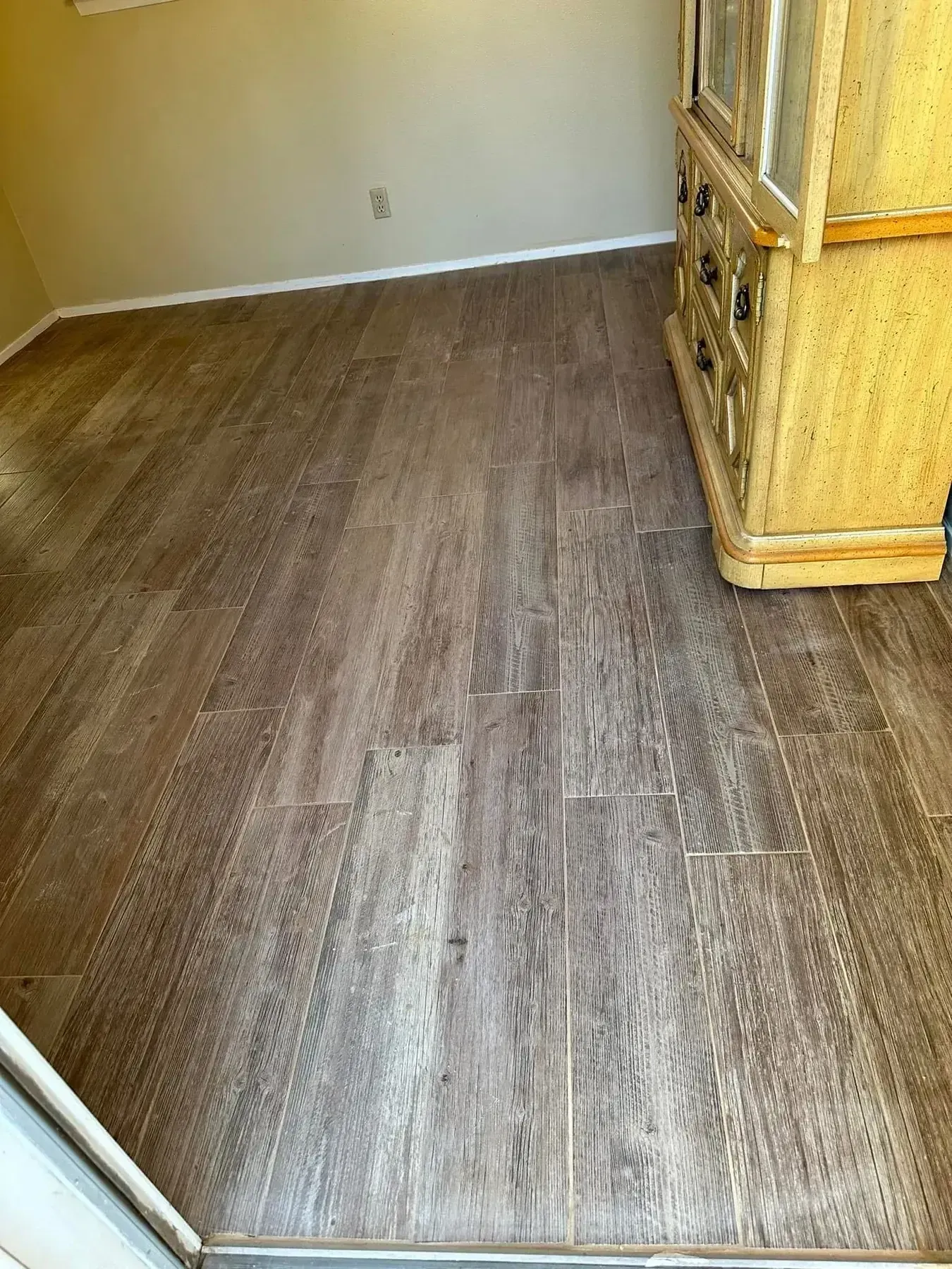 Empty room with wood-look flooring and a wicker dresser in the corner