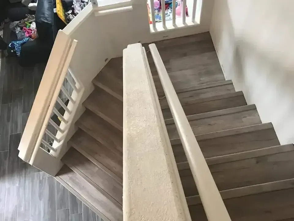Spiral staircase with beige carpet runner and wooden railing in a home interior