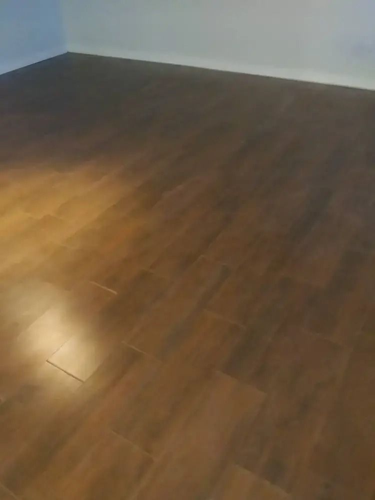 Empty room with brown wooden floor and white walls.
