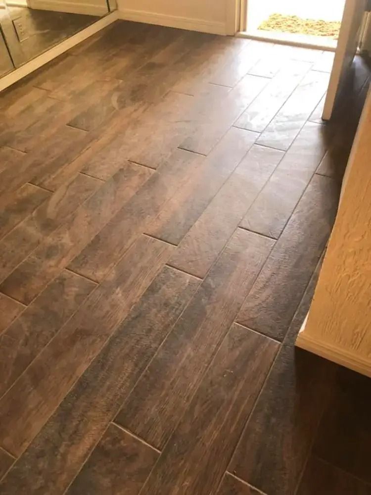 Dark wood kitchen floor with long planks and cabinets along the sides