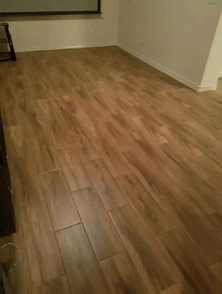 Empty room with light wood laminate flooring and white walls