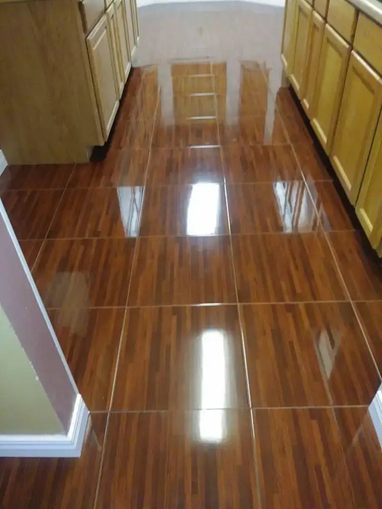 Glossy brown tiled hallway with cabinets on both sides and a small step ladder at the far end