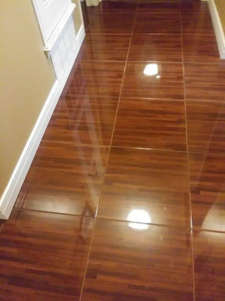 Shiny brown tiled hallway floor with white baseboards and a wall on the left.