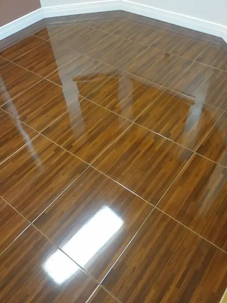 Glossy brown tiled floor reflecting windows and table legs in a room corner