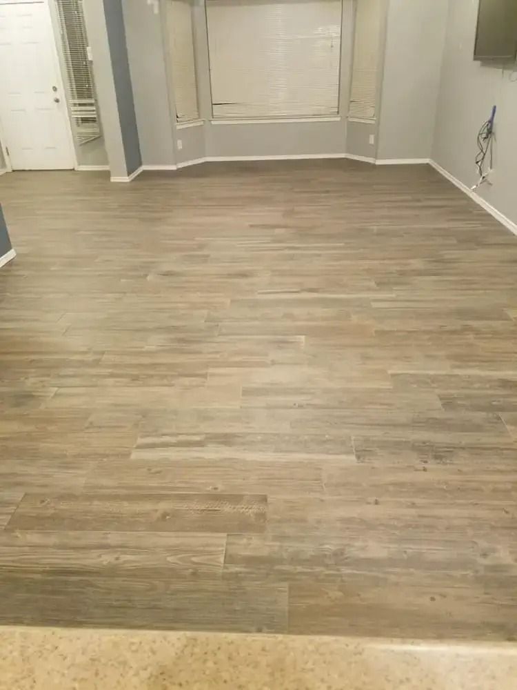 Empty room with light wood flooring, beige walls, and built-in wall panels.