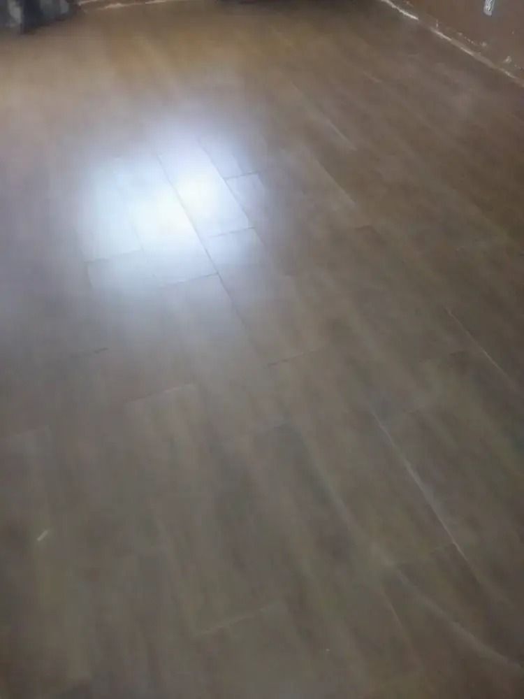 Empty room with a polished wooden floor and a bright reflection of light