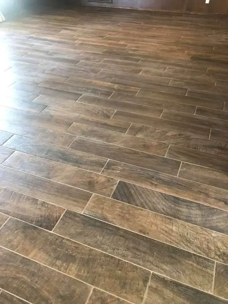 Close-up of dark wood-look plank flooring with sunlight reflecting across the surface