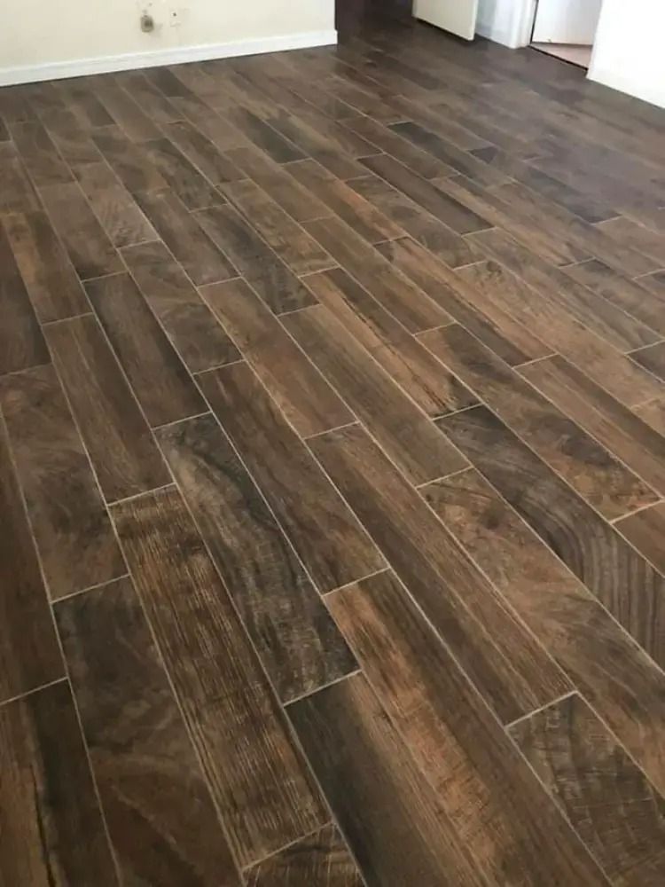 Dark wood-look laminate flooring in an empty room with white walls and trim