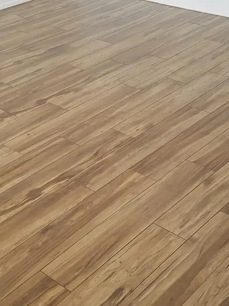 Wooden plank flooring with a light brown finish in an empty room