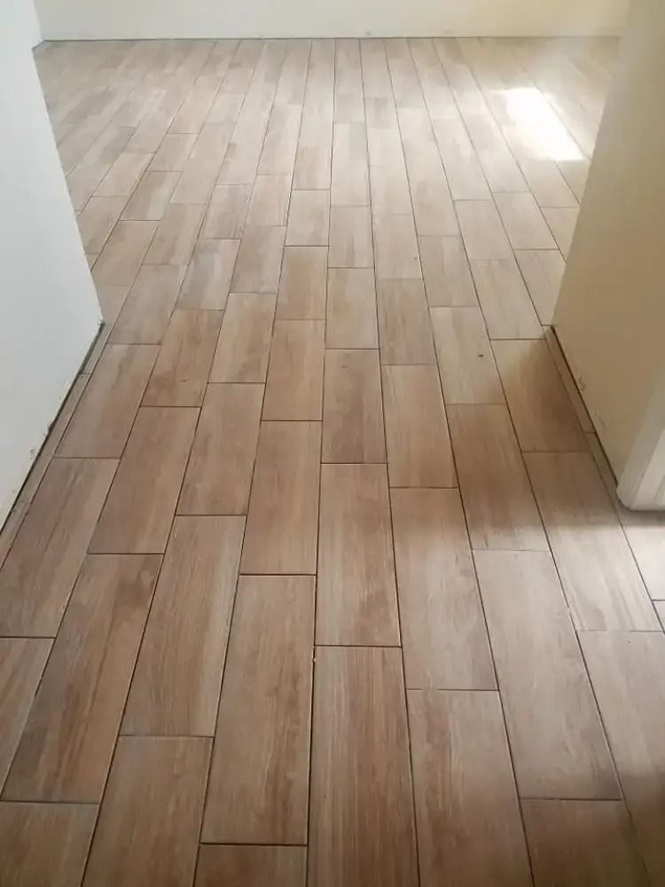 Empty hallway with light wood flooring and beige walls, viewed from a doorway