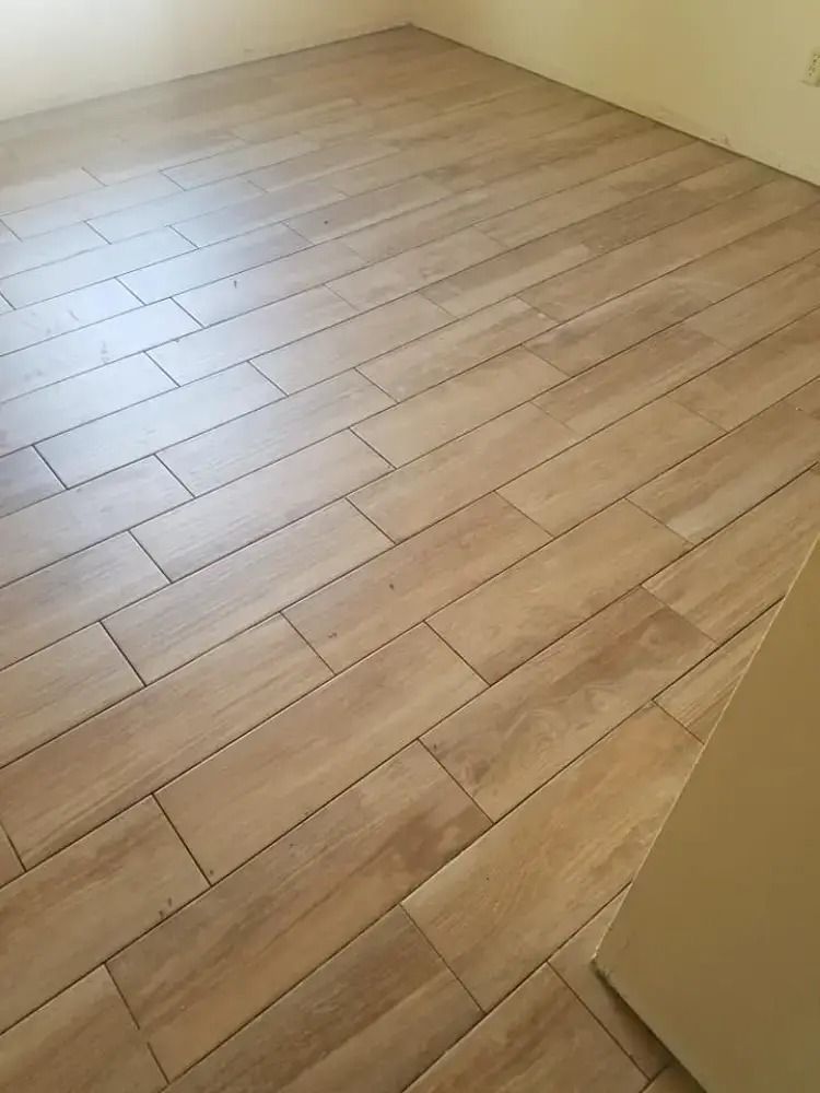 Empty room with light wood plank flooring and beige walls.