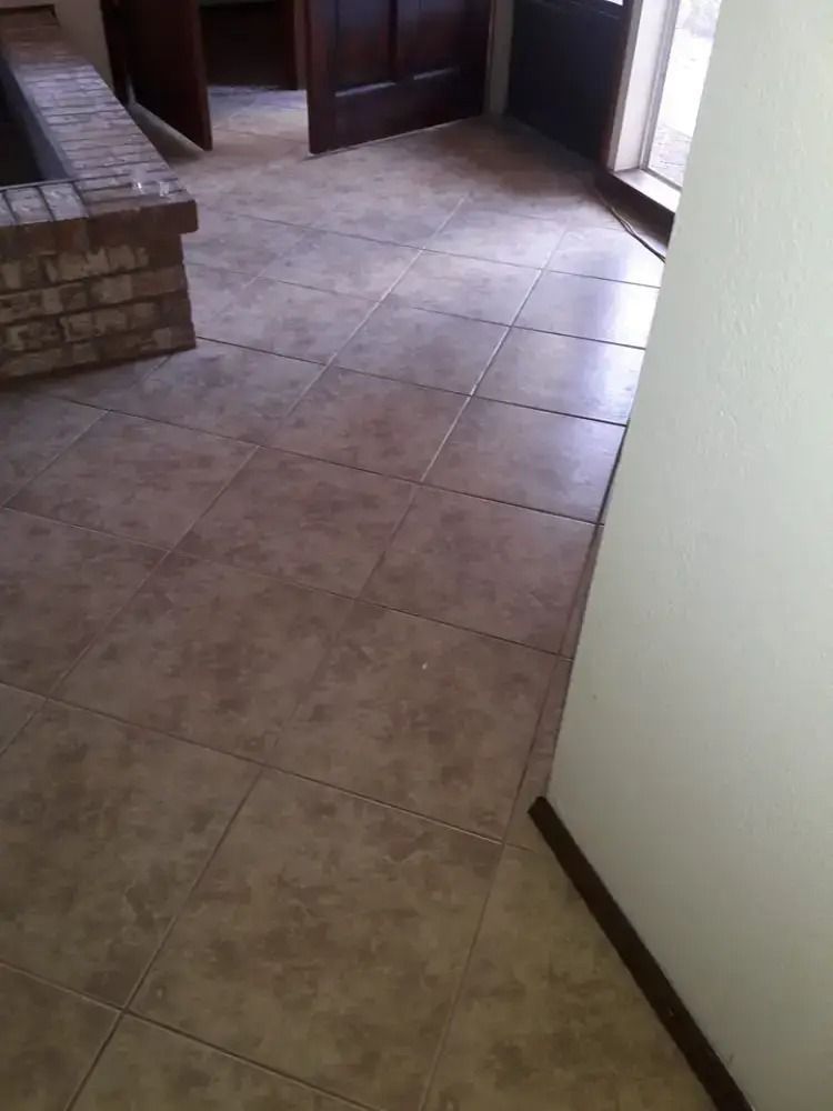 Tiled indoor hallway with a brick bench on the left and a doorway at the far end