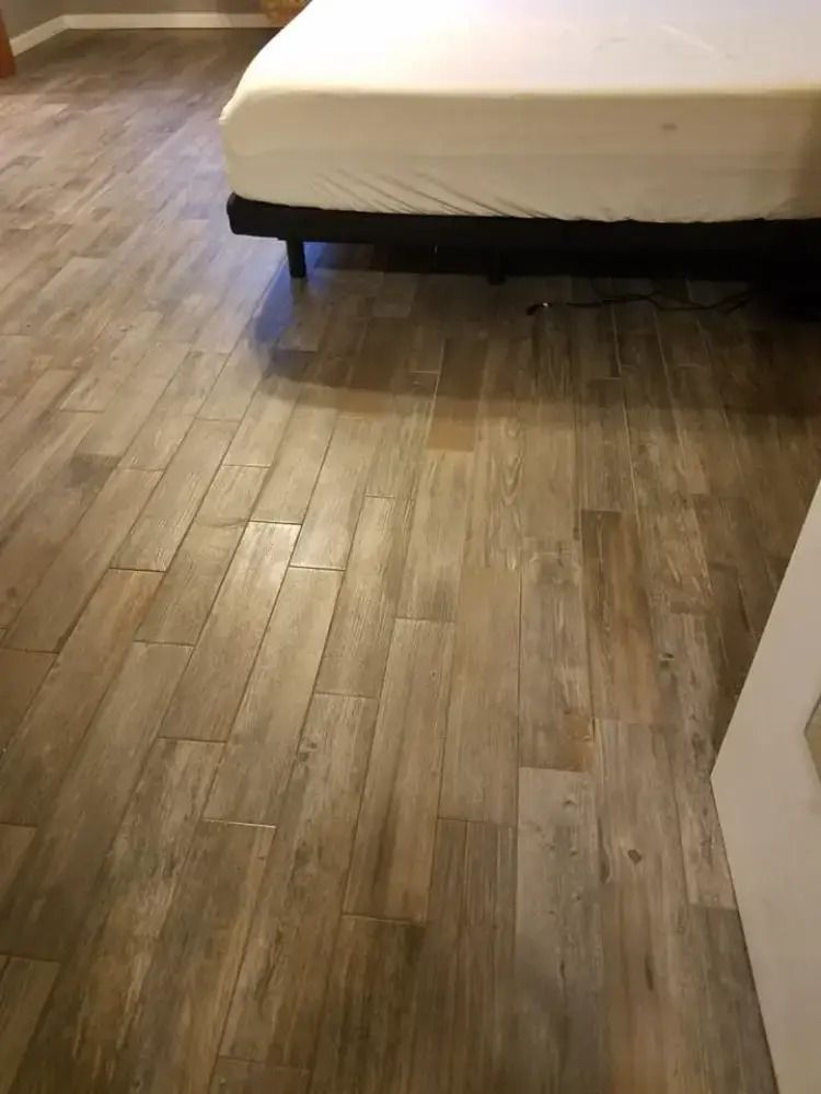 Bedroom with a bed on a wood floor and a doorway at right