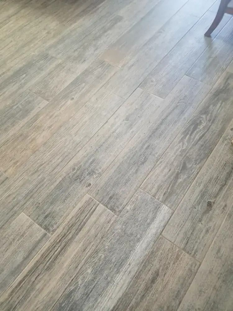 Light gray wood-pattern flooring with a chair leg visible at the top right.