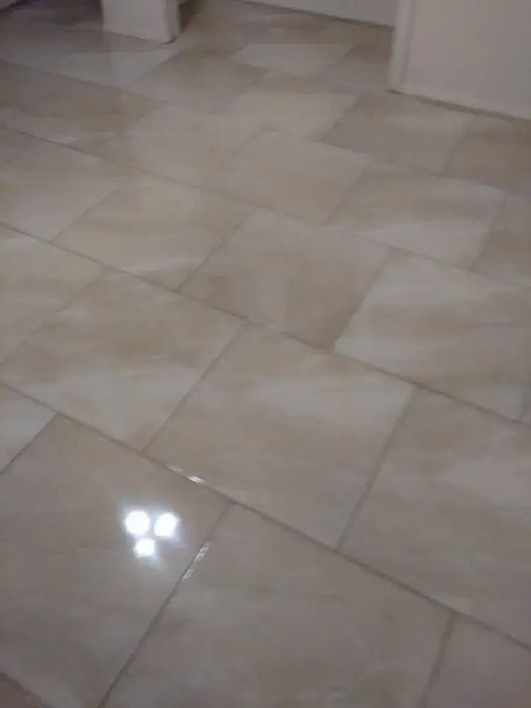 Glossy beige tiled floor with bright light reflection in an empty indoor space