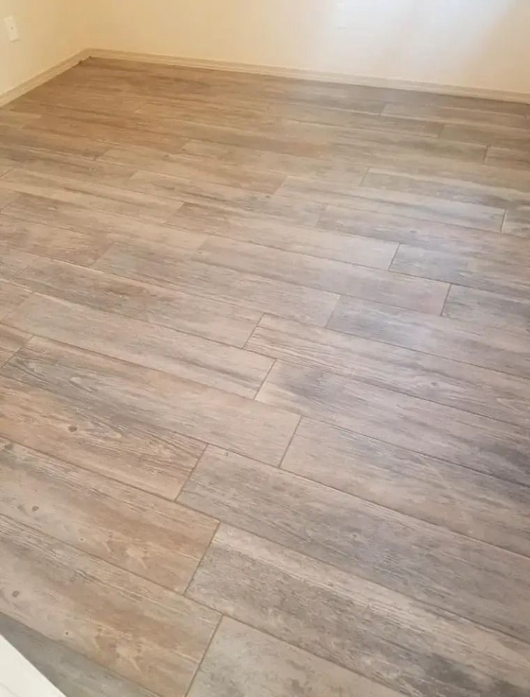 Empty room with light wood-look tile flooring and beige walls