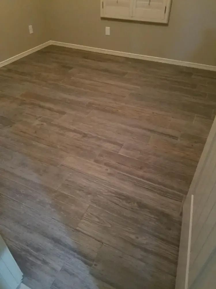 Empty room with gray wood-look flooring and beige walls, viewed from a doorway