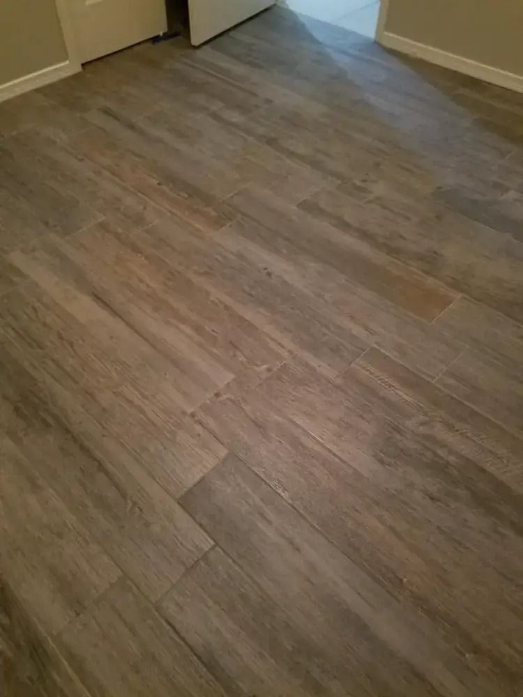 Empty room with gray-brown wood flooring and beige walls