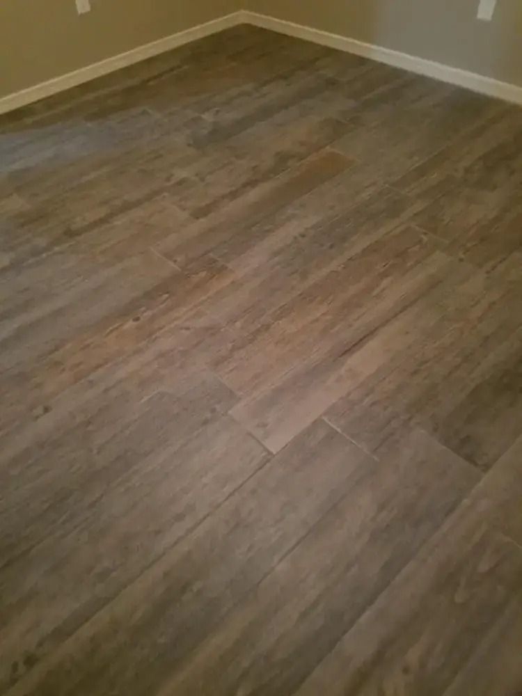 Empty room with wood-look flooring and beige walls.