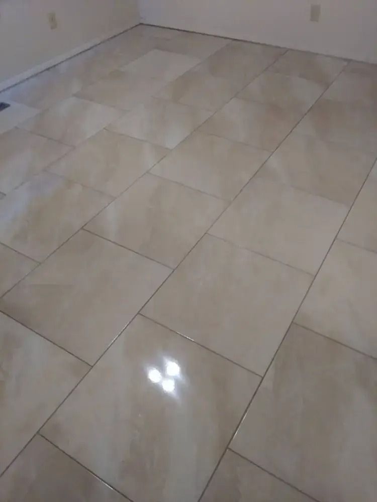 Empty room with glossy beige tile floor and white walls, seen from above.