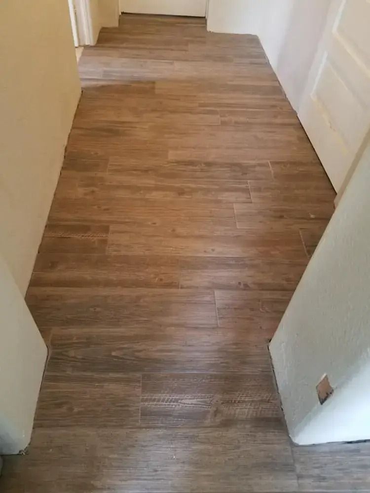 Narrow hallway with wood-look flooring and white doors on both sides