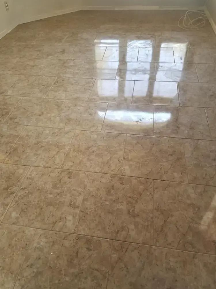Beige tiled floor with a window reflection and bright sunlight on the glossy surface