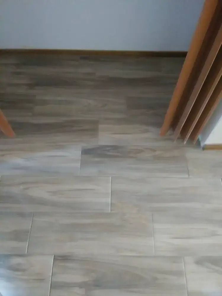 Wood-look tile floor at a doorway with wooden door frames on both sides