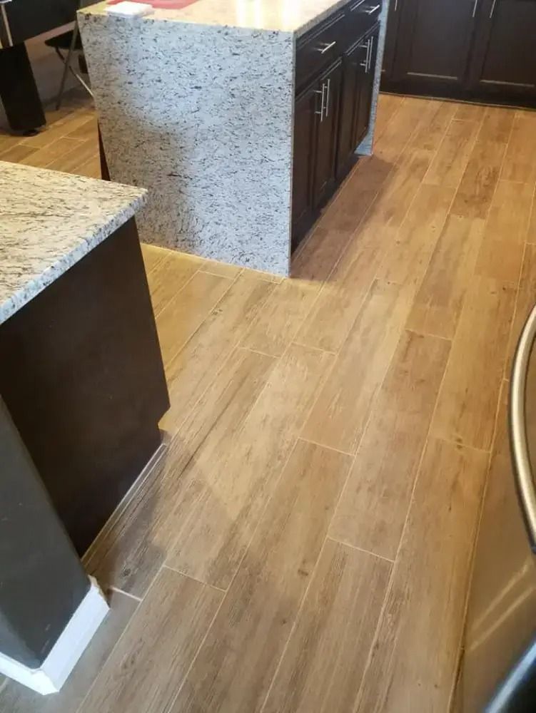 Kitchen with wooden floor, granite island, and dark cabinets