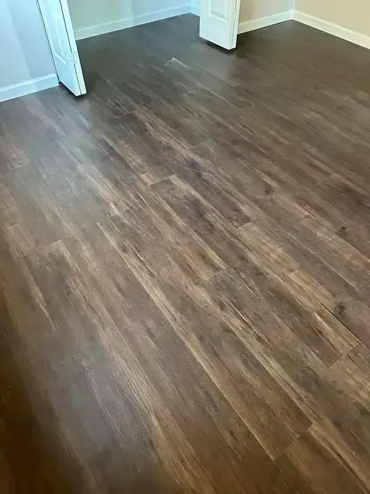 Wood-look laminate flooring in a room with white walls and a doorway