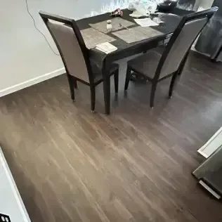 Dining area with a dark wood table and four chairs on a wood floor.