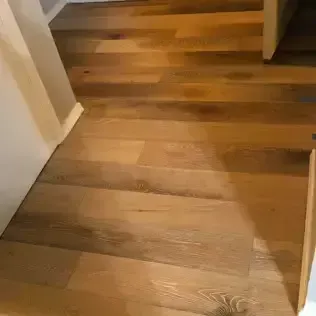 Wooden hallway floorboards with a small step up between rooms.