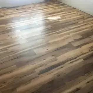 Empty room with a glossy light wood floor and white walls