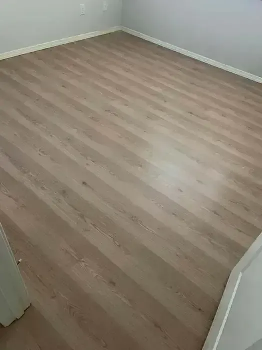 Empty room with light wood flooring and white walls, viewed from the doorway