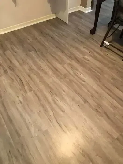Empty room with light wood flooring and a small table leg at the right edge.