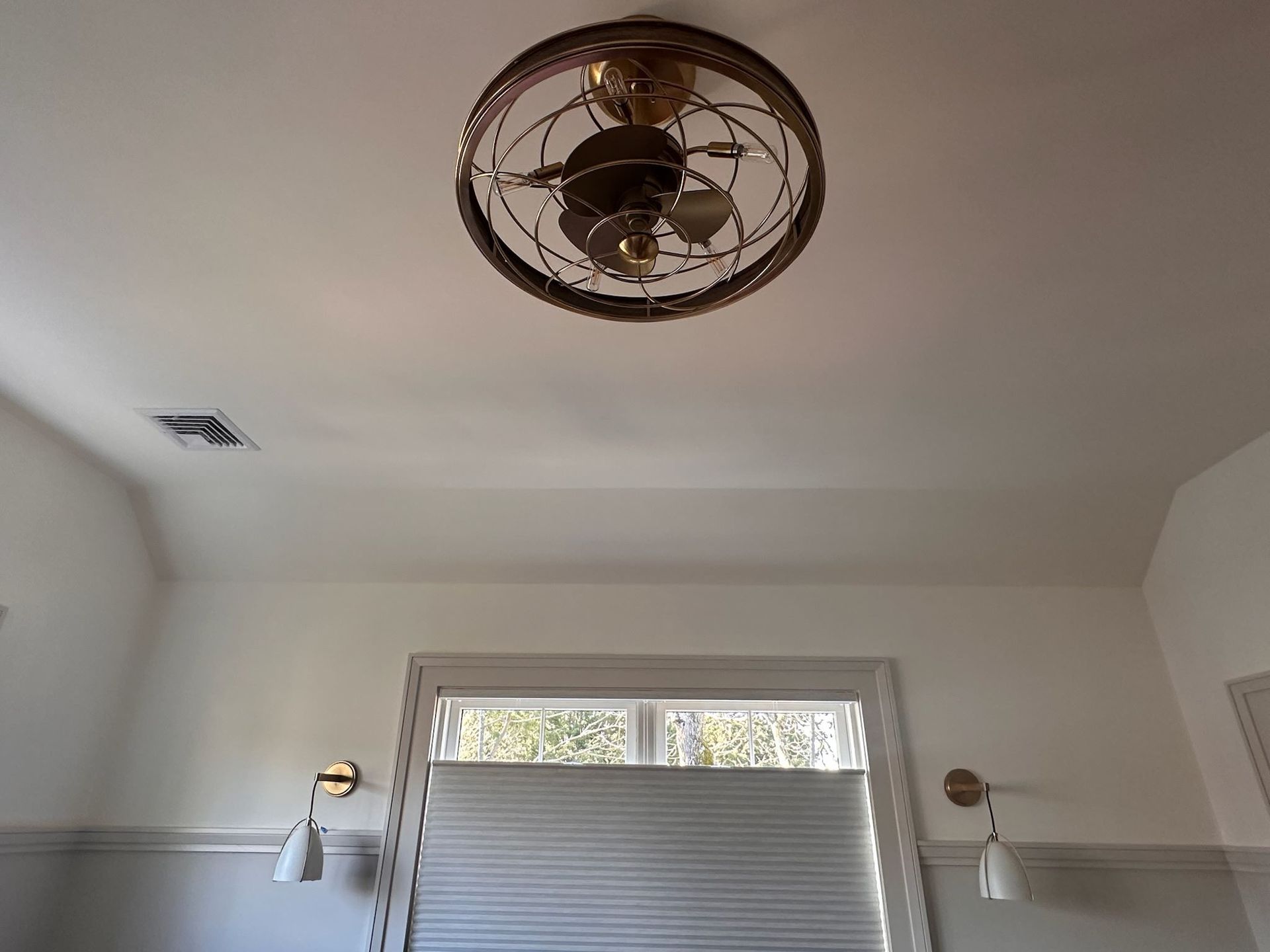 White room with a central ceiling fan light and a window with a partially closed blind.