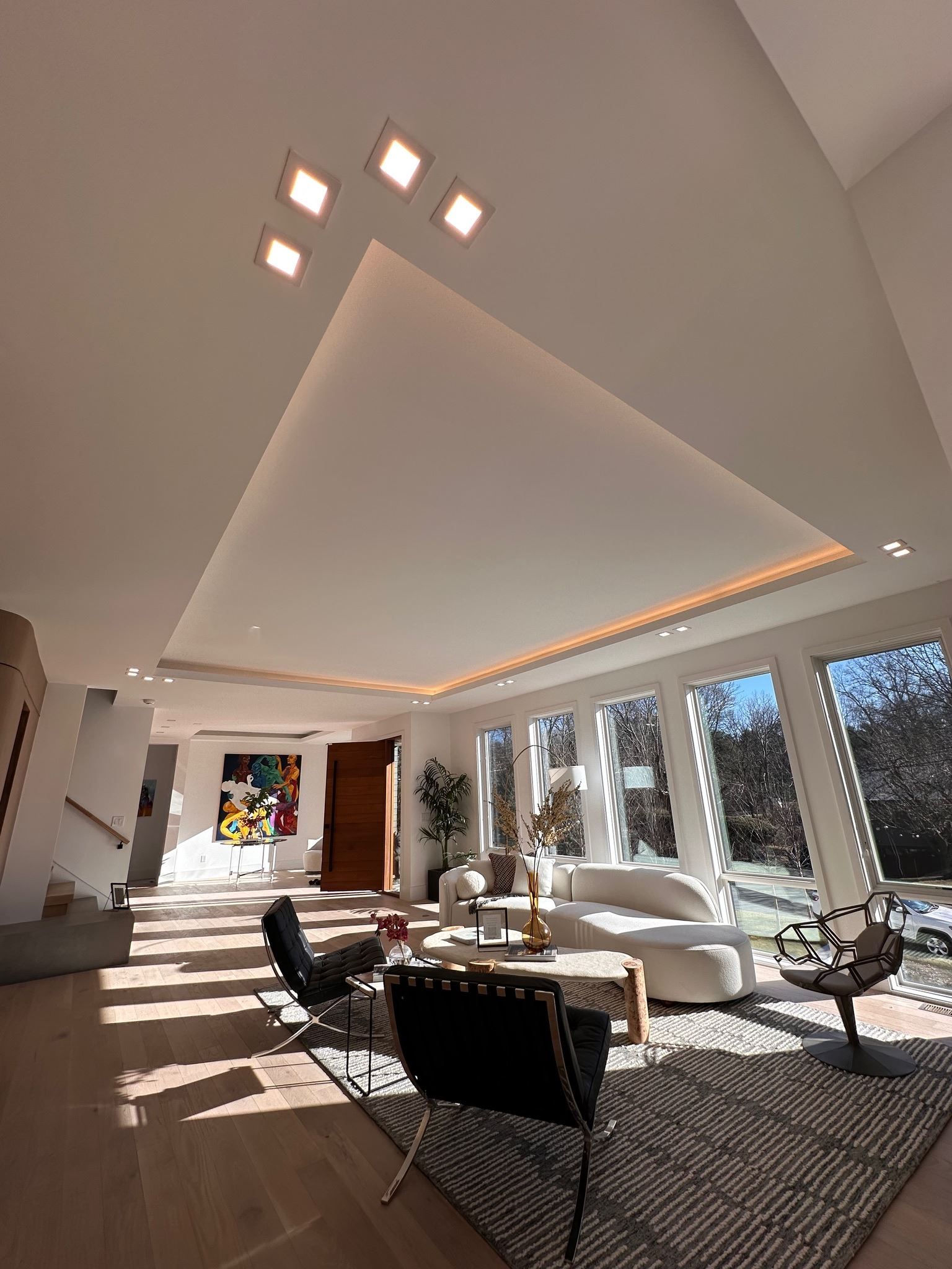 Bright modern living room with high vaulted ceiling, skylight windows, and sunlit seating area