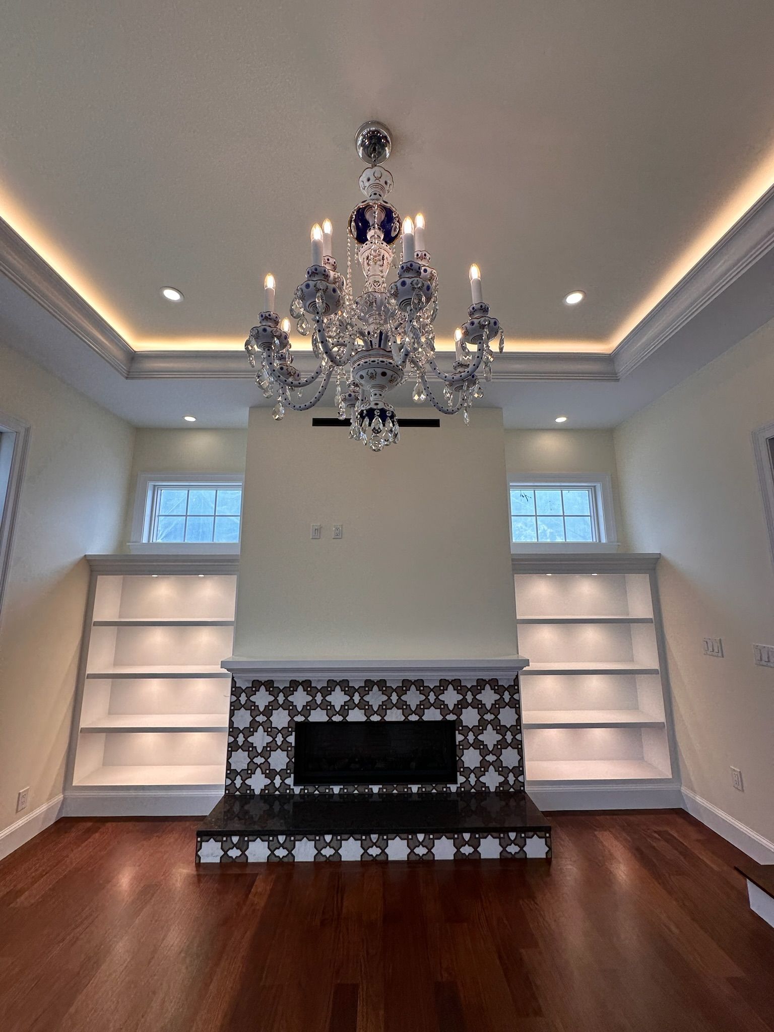 A living room with a fireplace and a chandelier hanging from the ceiling