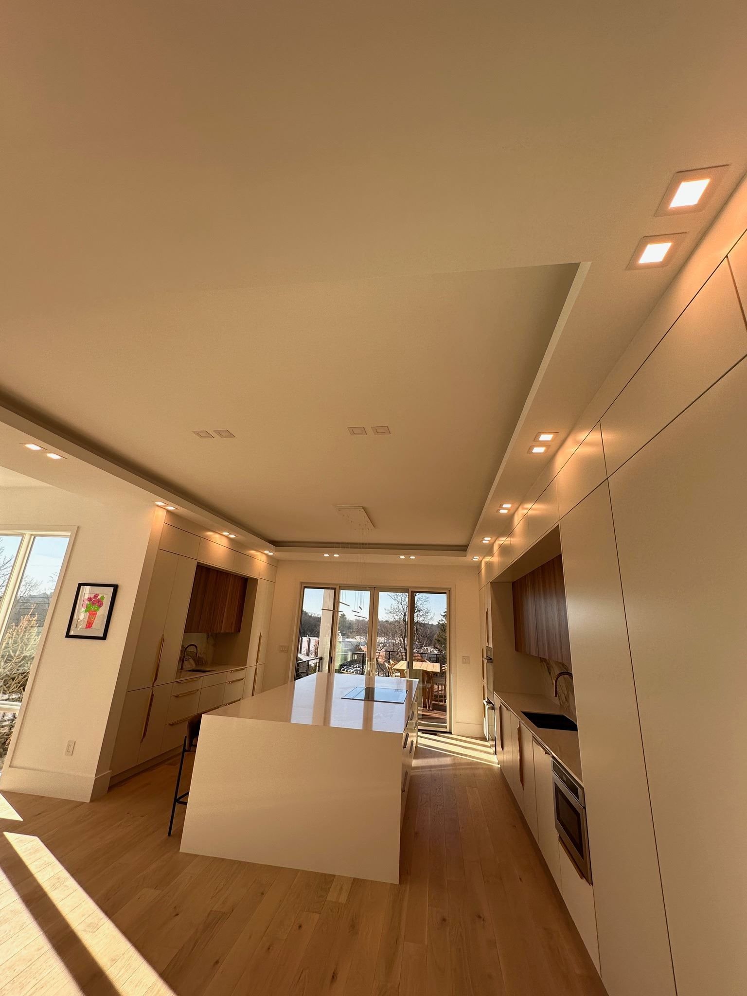 Modern minimalist living room with wood floors, white walls, and a central partition