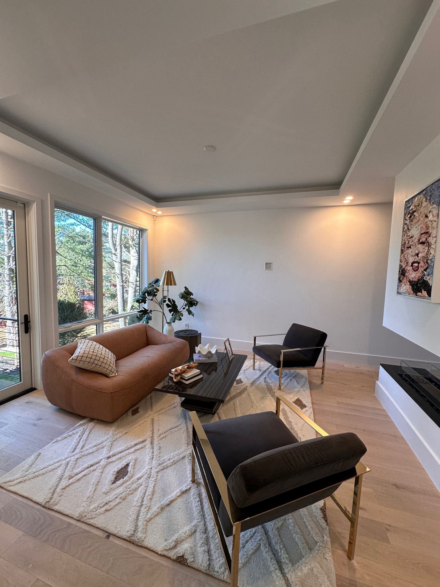 A living room with a couch , chairs , a coffee table and a fireplace.