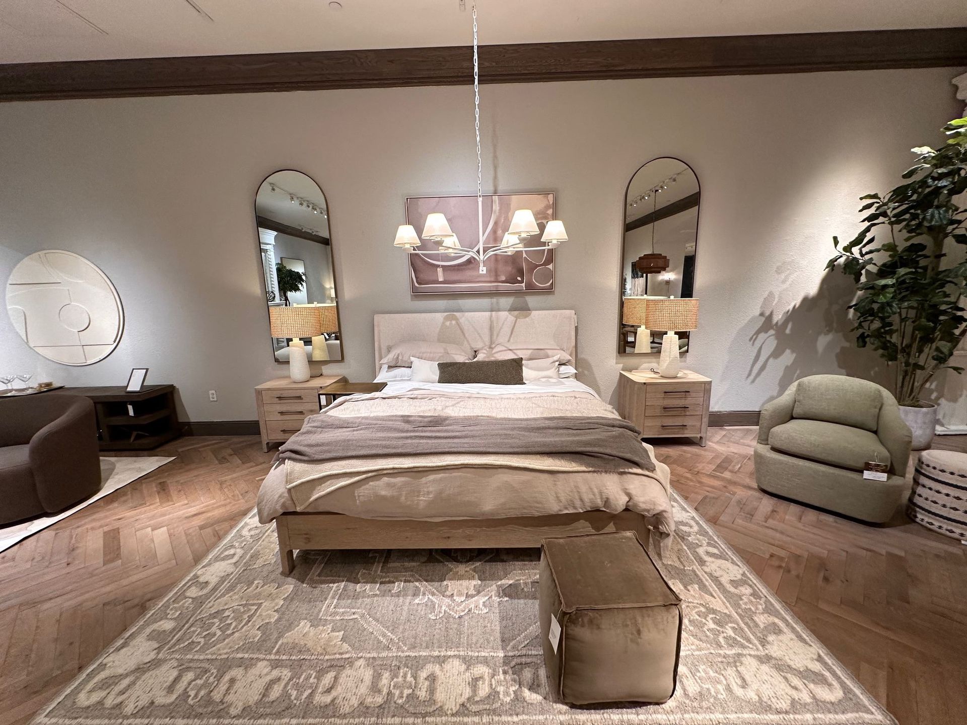 Cozy bedroom with a bed, rug, arched mirrors, bedside tables, and soft neutral decor