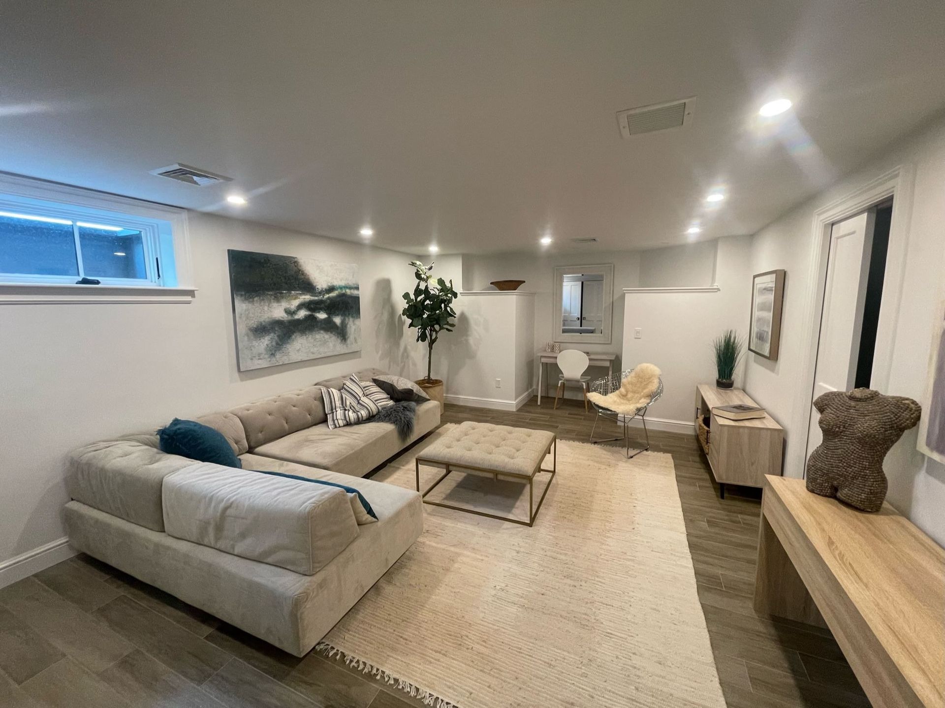 Modern living room with sectional sofa, coffee table, armchair, and warm neutral decor