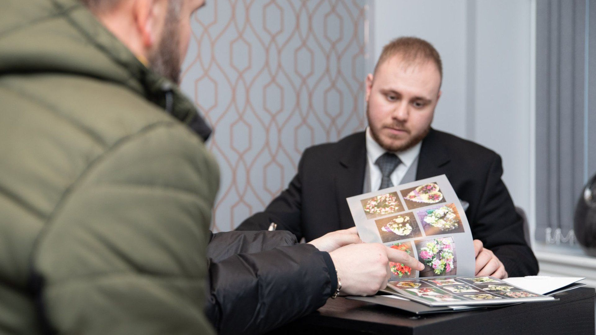 funeral director showing flower arrangements for a funeral