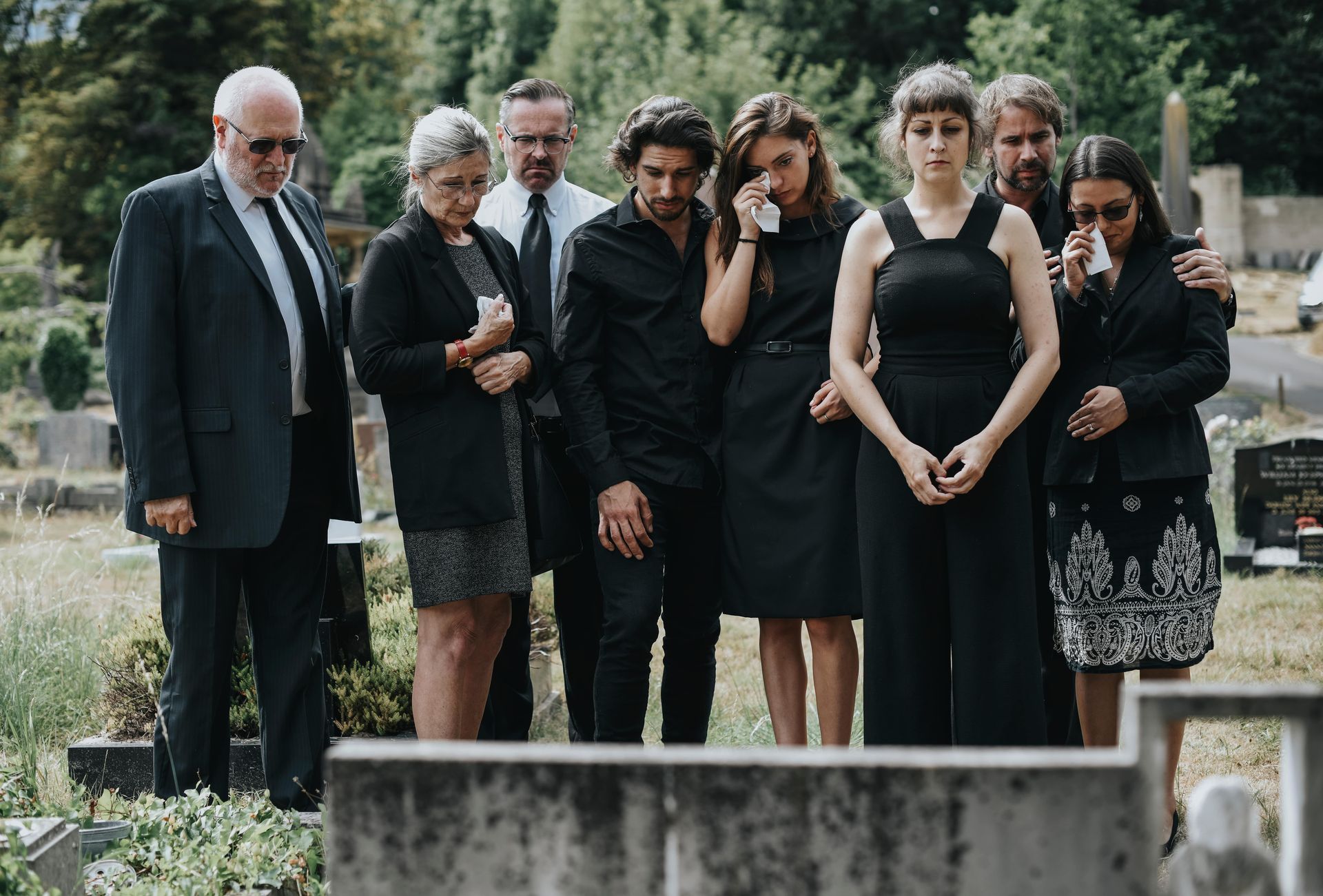 group paying respect at a tombstone